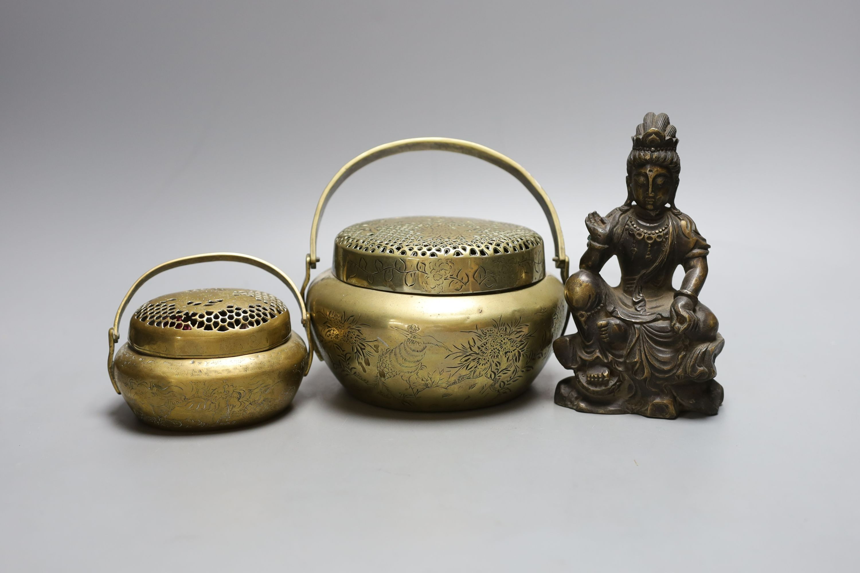 Two Chinese bronze hand warmers, one with Xuande mark, together with a seated Buddha, 16cm tall, (3)